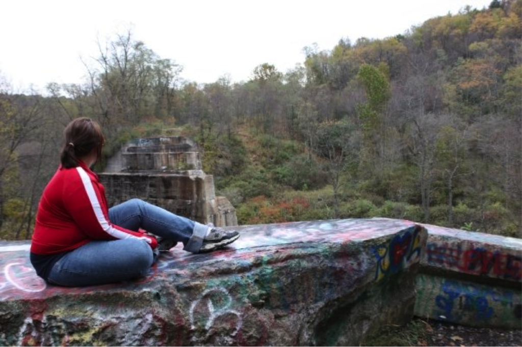 Picture of Carly sitting on a rock looking away from camera