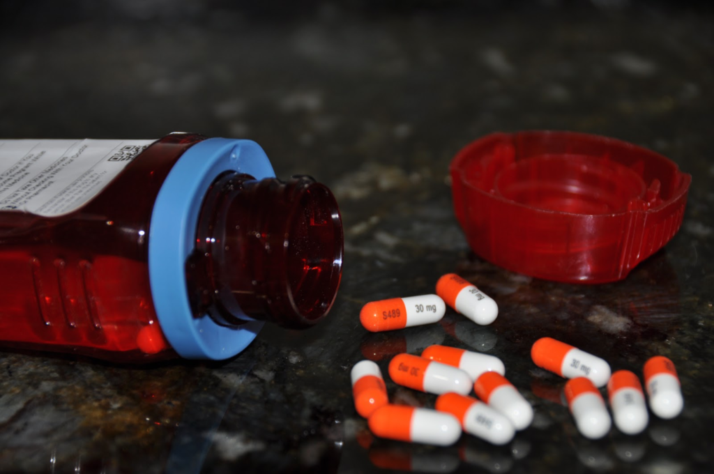 medicine bottle with pills spilled out around it