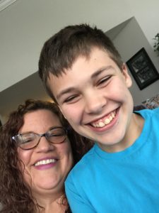 Kristen in glasses smiling with Aedan in blue t-shirt, also smiling. Aedan's mom has depression - he talks about it in the video in this post